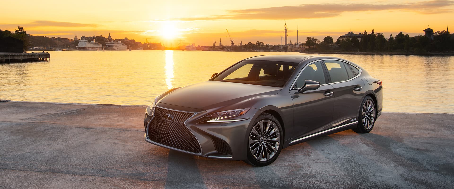 Silver Lexus LS being driven on sandy ground.